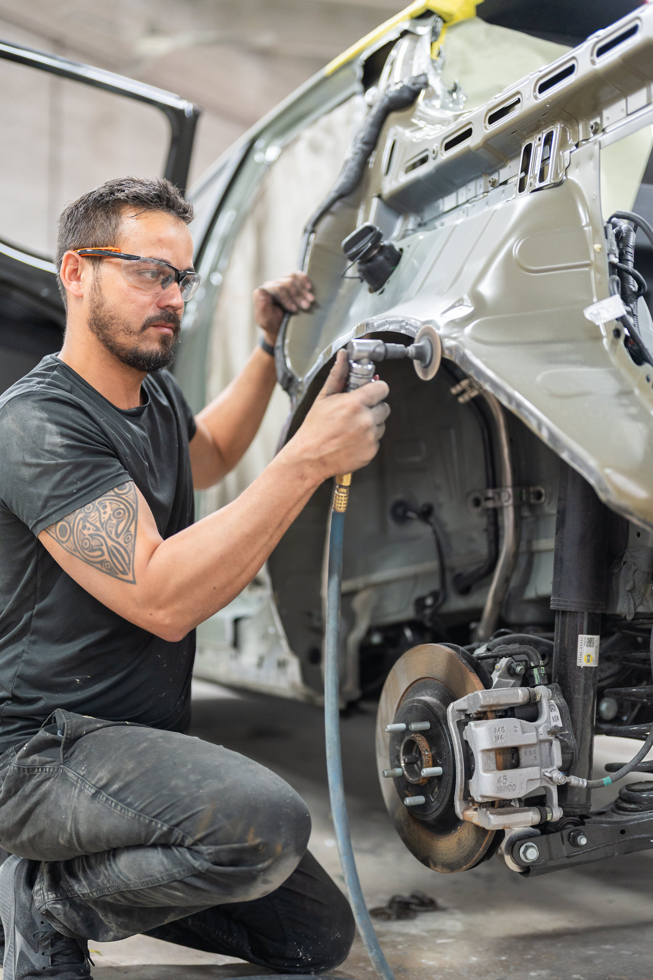 Precision technician performing auto dent repair on a vehicle panel in Miami